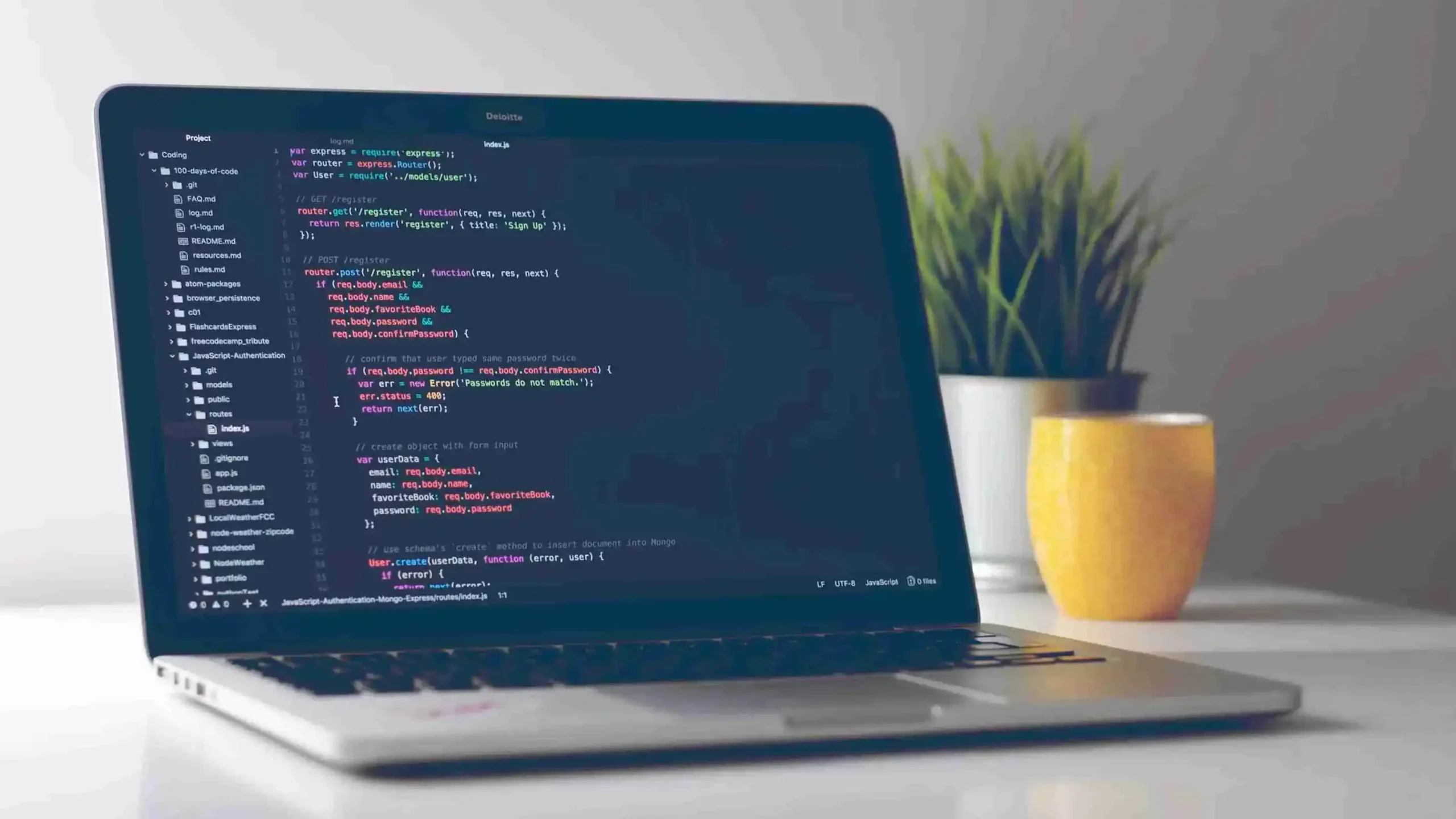 Laptop screen displaying backend code for a user registration route using JavaScript and Express.js, symbolizing web development and programming.